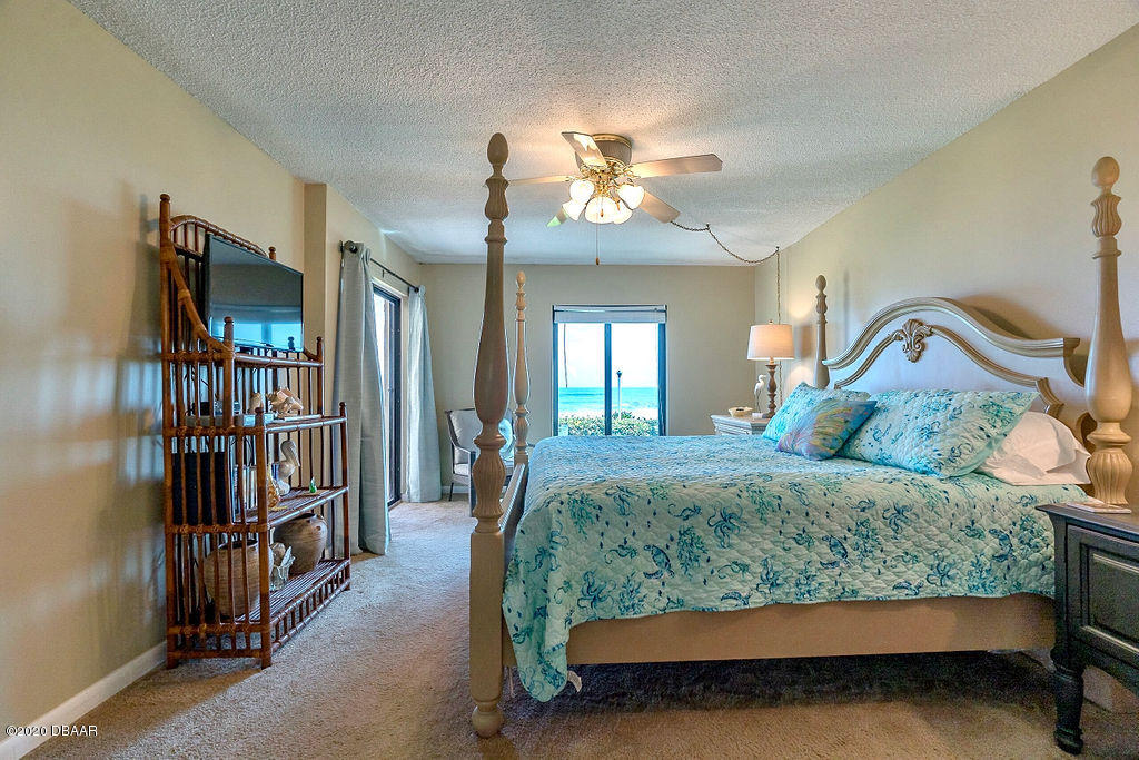 1275 Ocean Shore Boulevard, Unit 108 Ormond Beach, FL 32176 - Photo 14 of 26 a bed sitting in a bedroom next to a tv