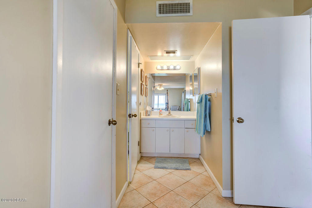 1275 Ocean Shore Boulevard, Unit 108 Ormond Beach, FL 32176 - Photo 17 of 26 a bathroom with a glass shower door and a mirror