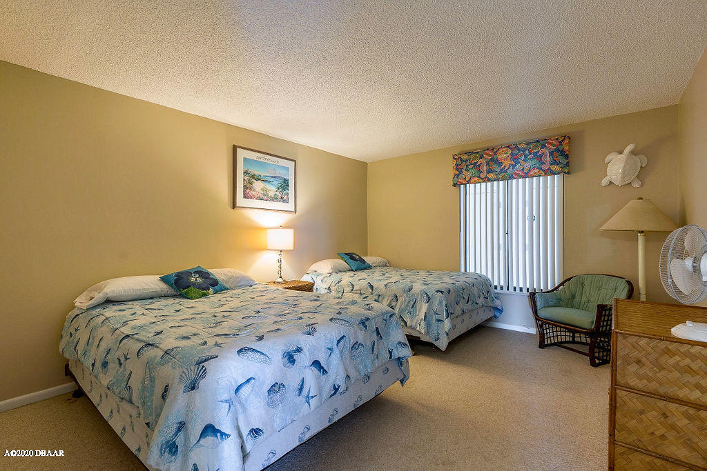 1275 Ocean Shore Boulevard, Unit 108 Ormond Beach, FL 32176 - Photo 19 of 26 a bedroom with a bed chair and window