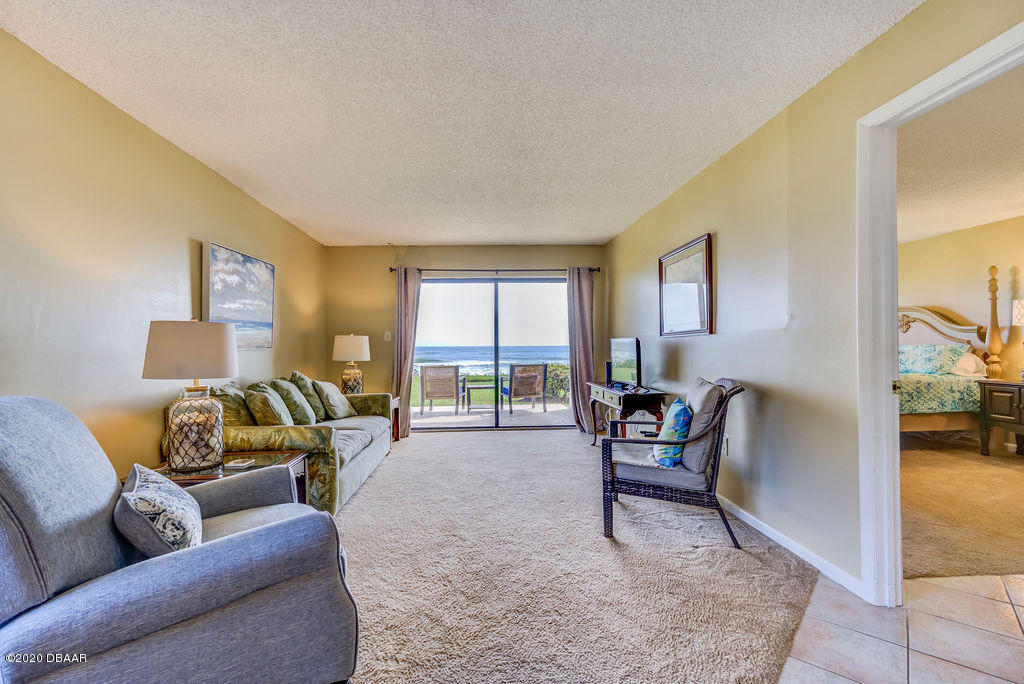 1275 Ocean Shore Boulevard, Unit 108 Ormond Beach, FL 32176 - Photo 3 of 26 a living room with furniture and a large window