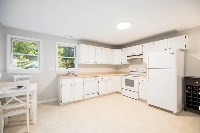 a kitchen with white cabinets and white appliances