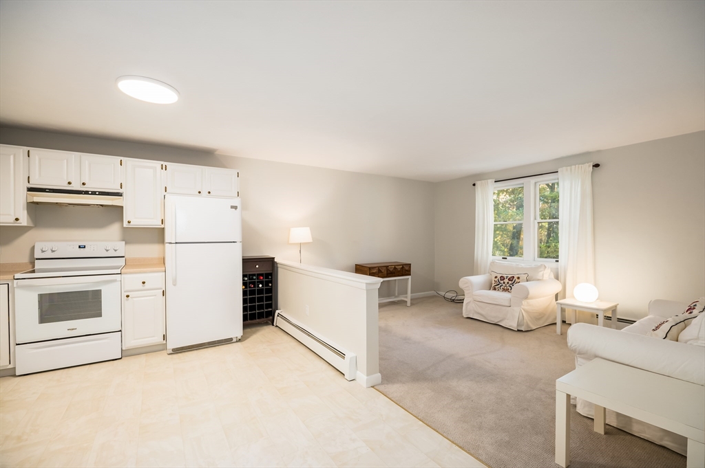 92 Pleasant Street Wenham, MA 01984 - Photo 23 of 33 a kitchen with a stove a refrigerator and white cabinets
