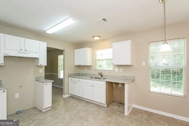 a kitchen with a sink stove and cabinets