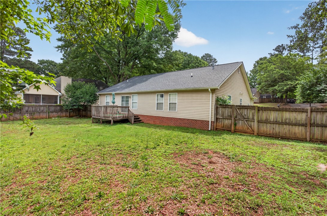 207 Hunters Lane Anderson, SC 29625 - Photo 5 of 46 A secluded backyard features a wooden fence, a spacious deck, and plenty of space to enjoy and relax.