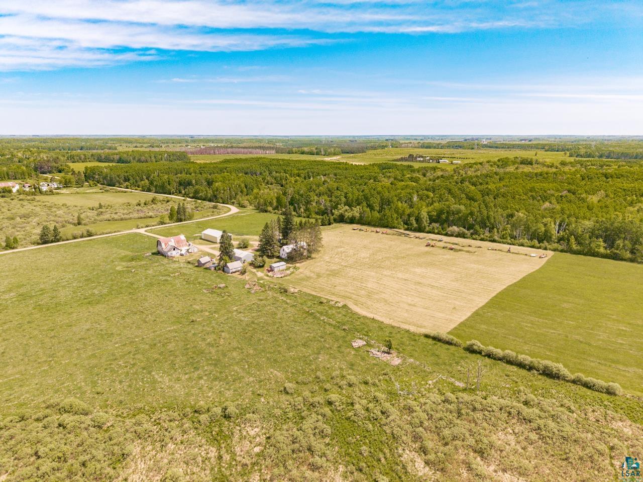 6606 Metso Road Kettle River, MN 55757 - Photo 54 of 84 Expansive agricultural property featuring multiple structures, open fields, and surrounding woodland