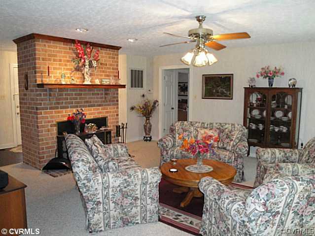 1010 Milby Town Road Shacklefords, VA 23156 - Photo 17 of 24 a living room with furniture a chandelier and a fireplace