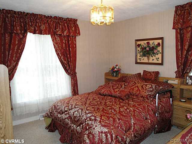 1010 Milby Town Road Shacklefords, VA 23156 - Photo 24 of 24 a bed sitting in a bedroom next to a window