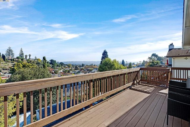 a view of balcony with wooden floor & fence
