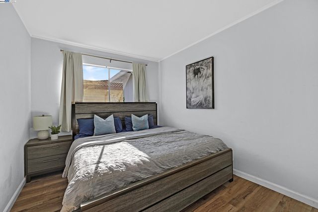 a bedroom with a bed and a painting on the wall