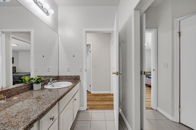 a bathroom with a granite countertop double vanity sink and a mirror