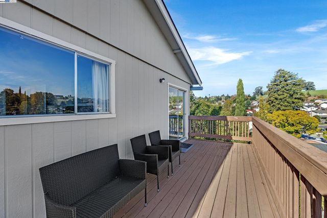 a balcony with wooden floor and outdoor seating
