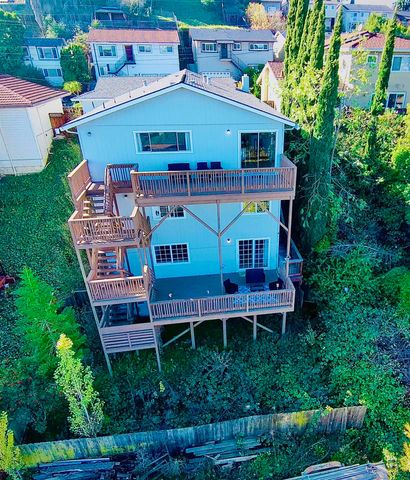 an aerial view of a house with balcony and trees al around