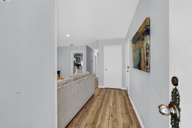 a view of a hallway to a livingroom with furniture and wooden floor