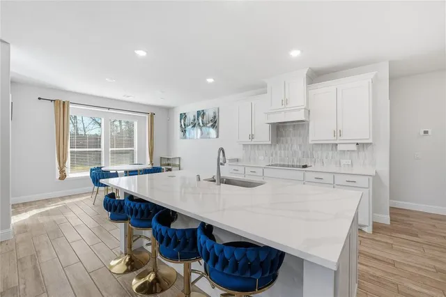 a kitchen with a sink a stove a refrigerator and white cabinets