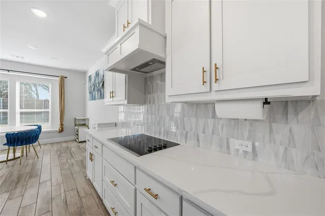 a kitchen with white cabinets and stainless steel appliances