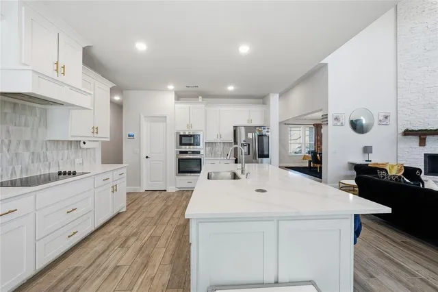a view of a refrigerator in kitchen and an empty room