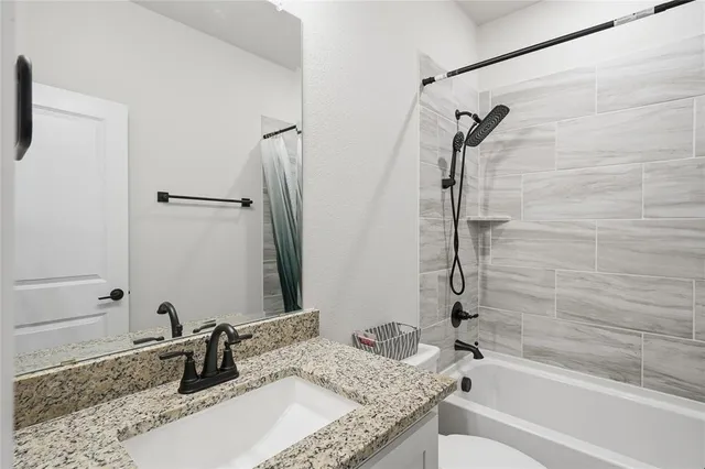 a bathroom with a granite countertop sink toilet and shower