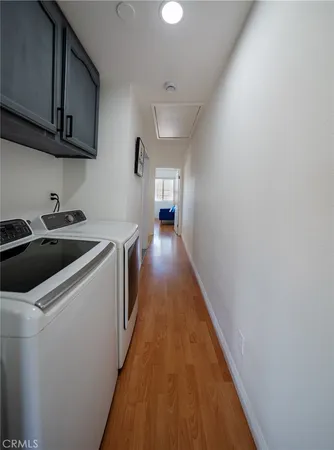 a view of a hallway with wooden floor and a living room