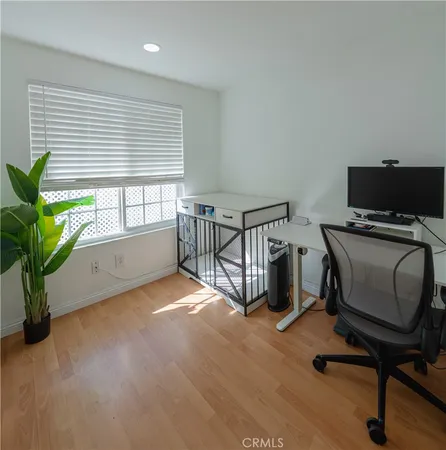 a view of a workspace with furniture and a window