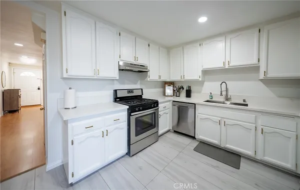 a kitchen with granite countertop white cabinets and white appliances