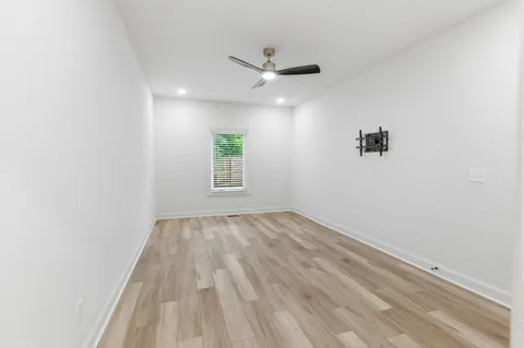 an empty room with windows and ceiling fan view