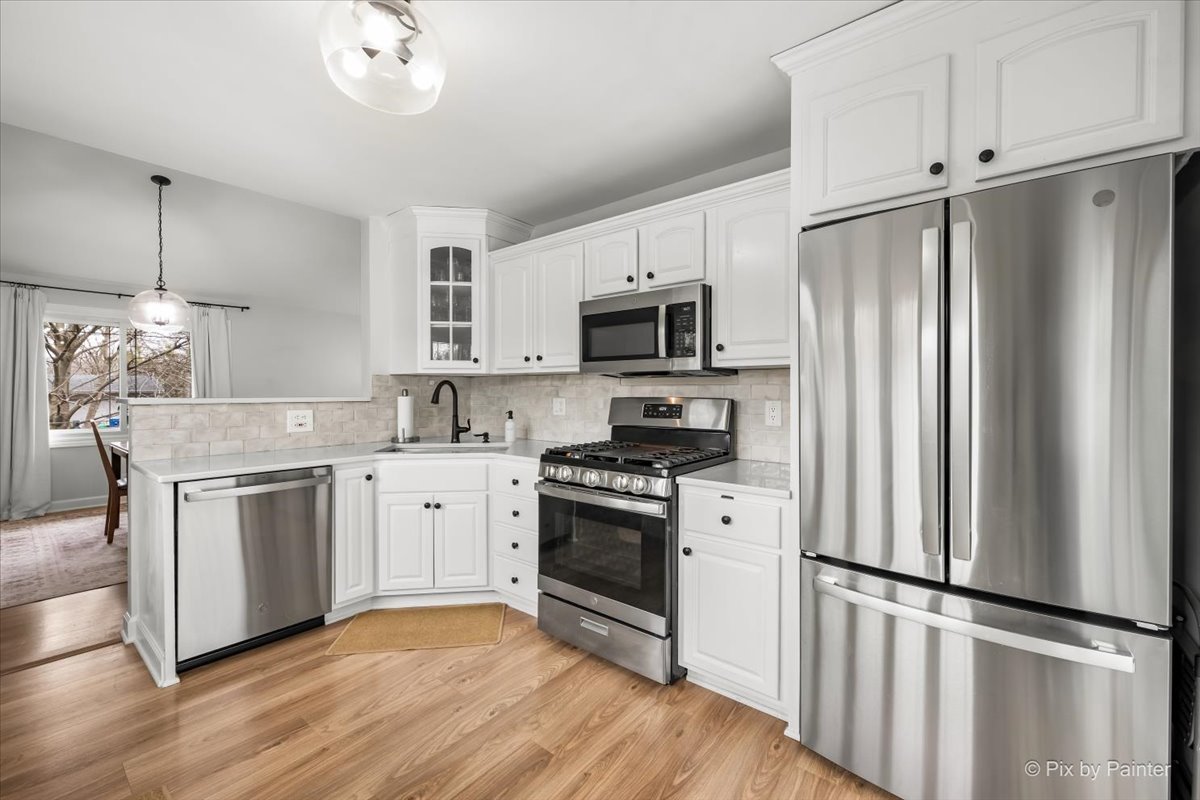 1908 Moore Avenue St. Charles, IL 60174 - Photo 12 of 45 a kitchen with cabinets stainless steel appliances and wooden floor