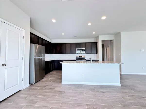 a view of kitchen with stainless steel appliances kitchen island sink refrigerator and stove