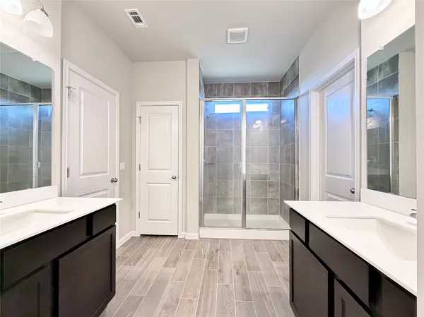 a bathroom with a double vanity sink and mirror
