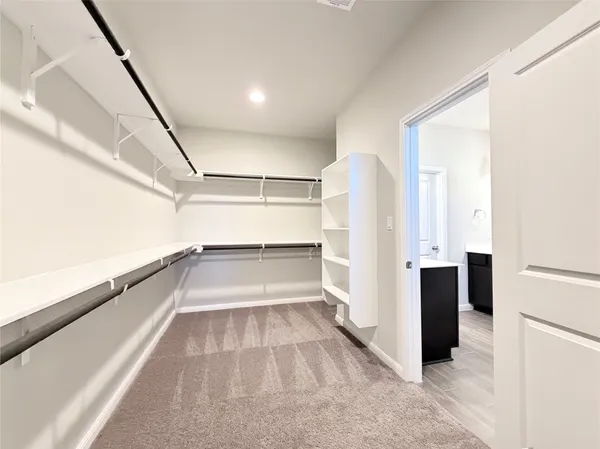 a view of walk in closet with empty racks
