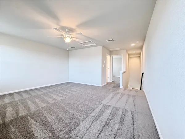 a view of a big room with wooden floor and a ceiling fan