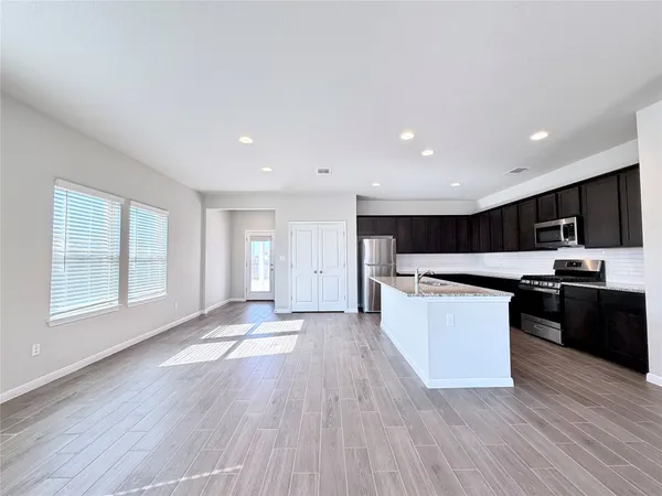 a large kitchen with a large counter top and stainless steel appliances