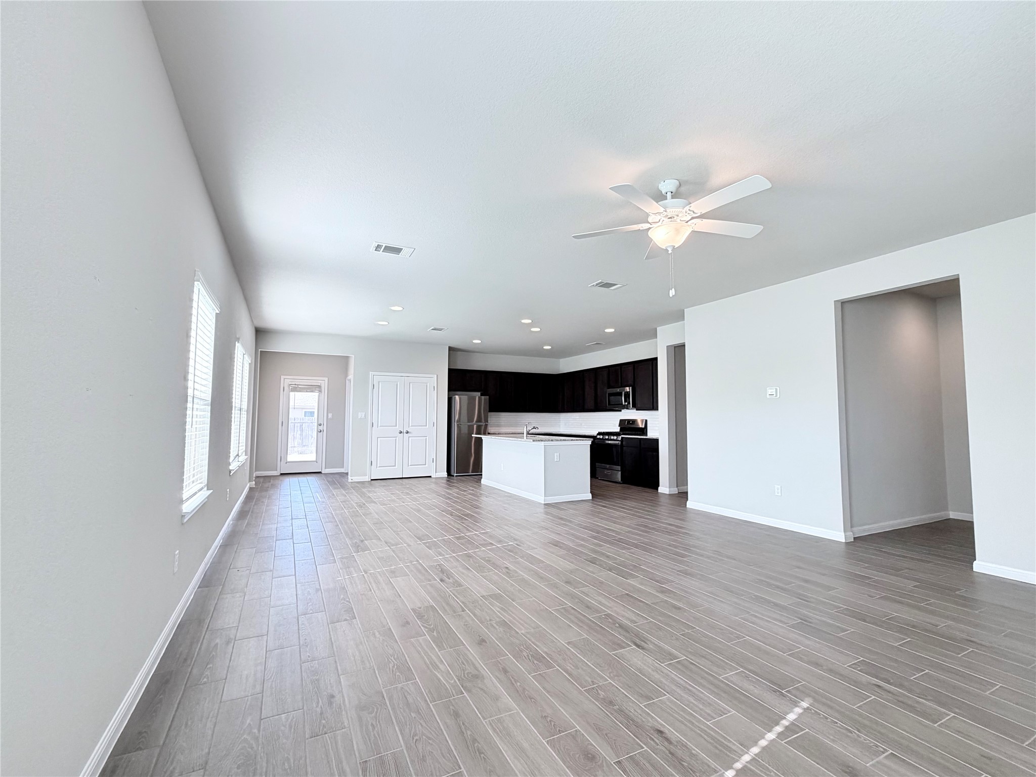 18104 Emu Lane Manor, TX 78653 - Photo 8 of 39 a view of an empty room with wooden floor and a ceiling fan
