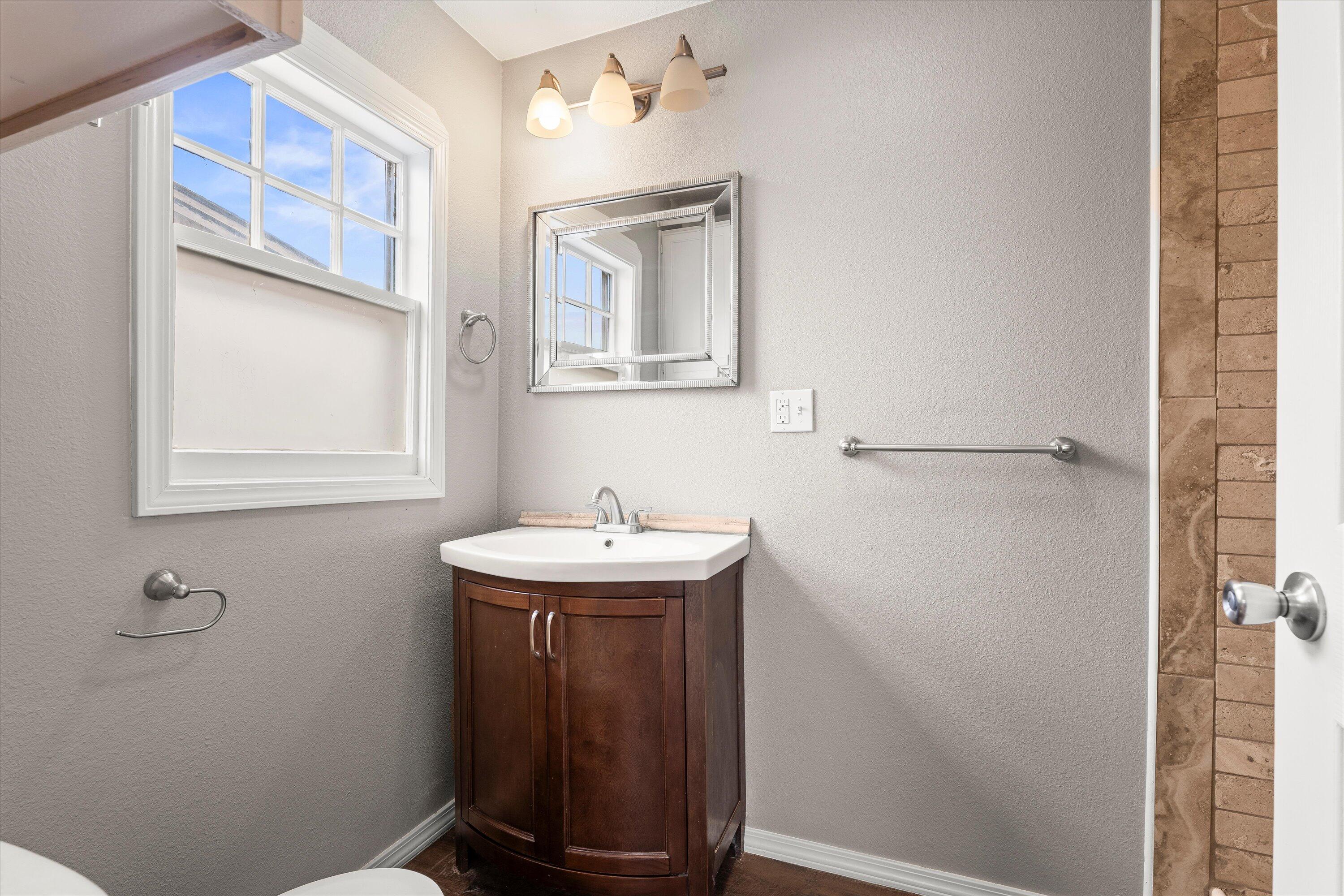 204 Ave L Levelland, TX 79336 - Photo 14 of 27 a bathroom with a sink a toilet and mirror