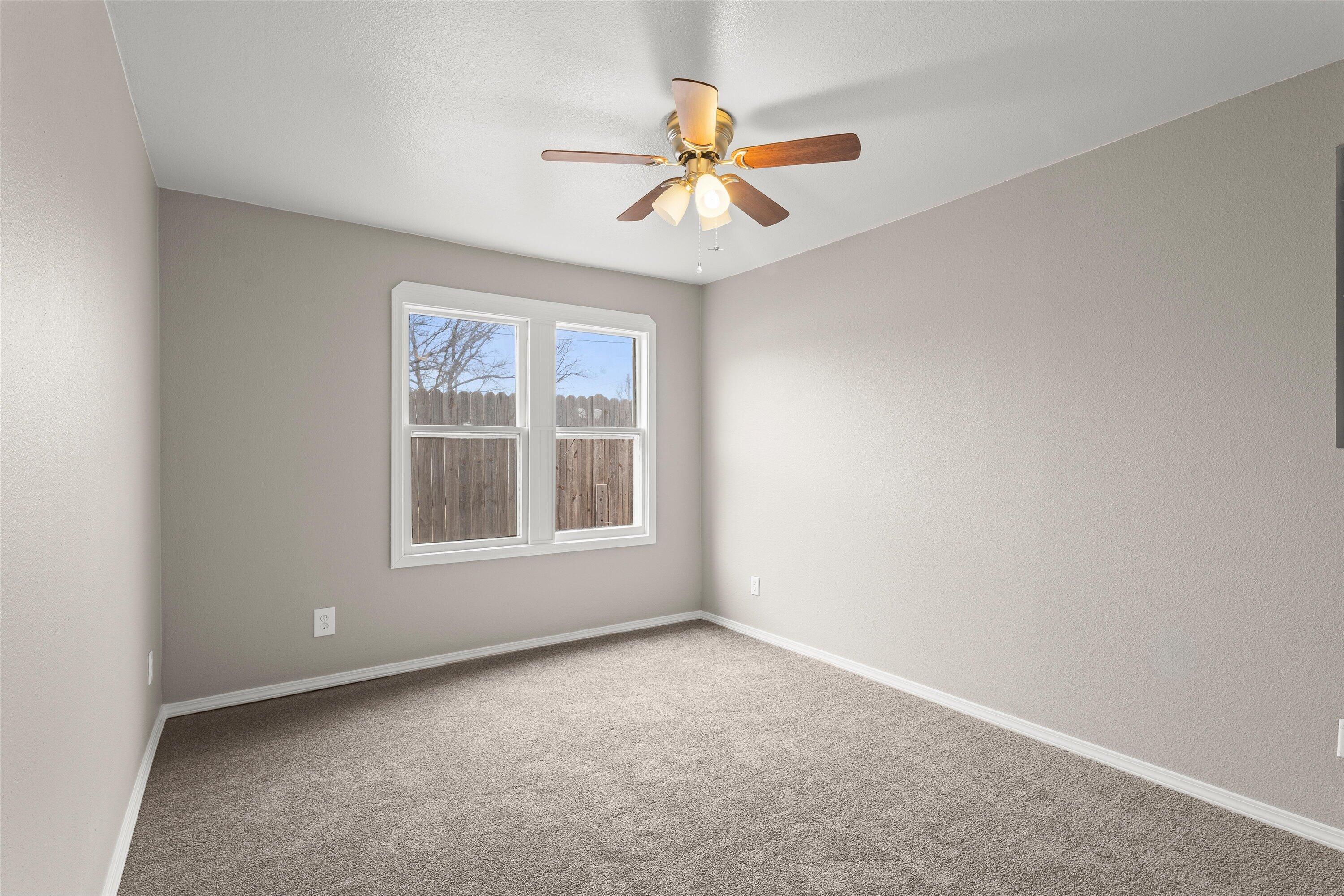 204 Ave L Levelland, TX 79336 - Photo 16 of 27 an empty room with a window and a fan