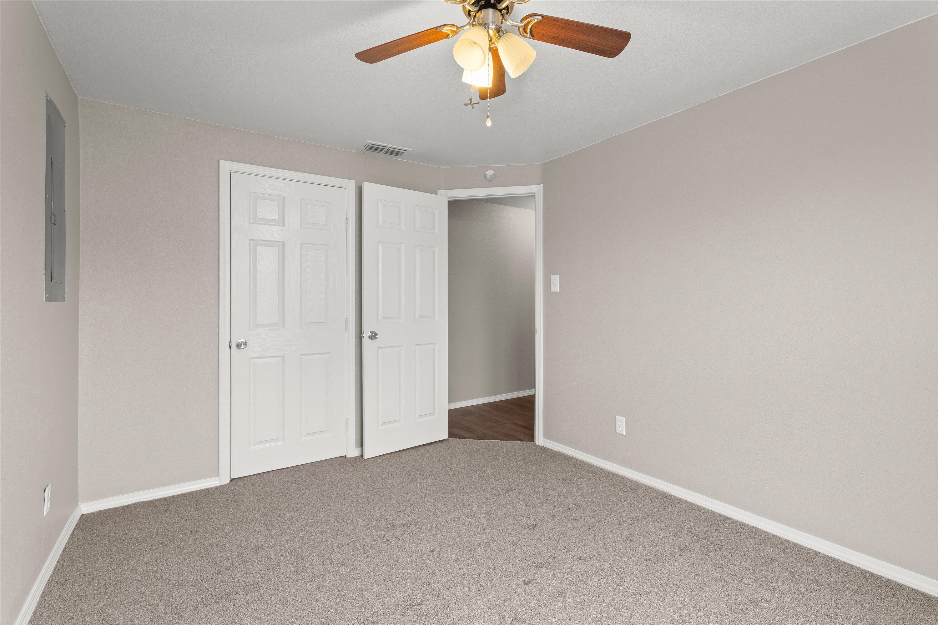 204 Ave L Levelland, TX 79336 - Photo 17 of 27 an empty room with a chandelier fan and windows