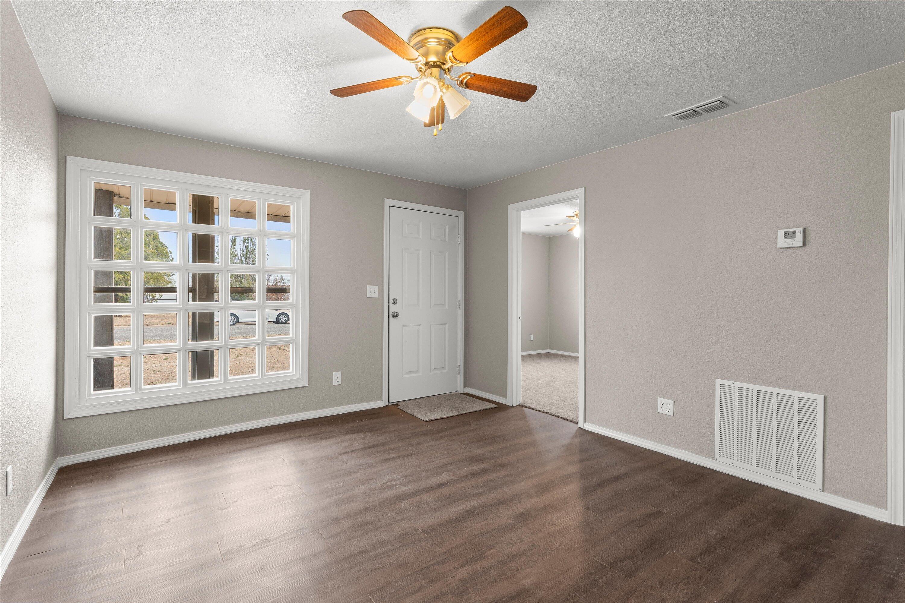204 Ave L Levelland, TX 79336 - Photo 5 of 27 wooden floor in an empty room with a window