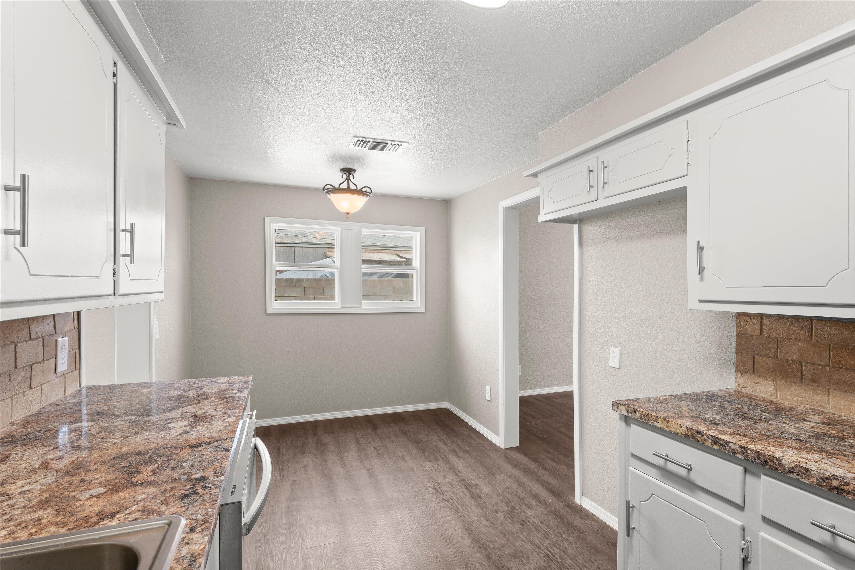 204 Ave L Levelland, TX 79336 - Photo 9 of 27 a kitchen with granite countertop a stove and a sink