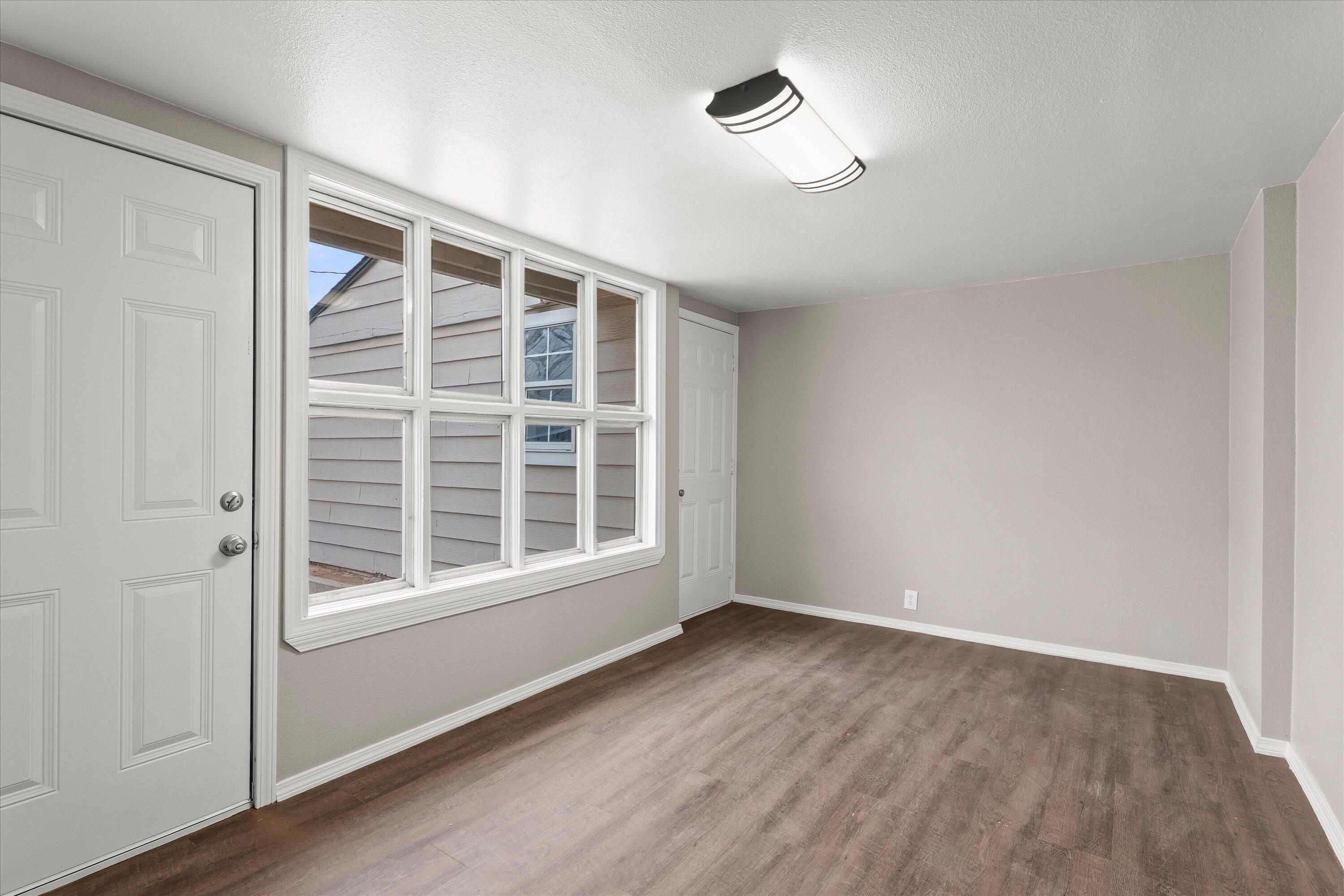 204 Ave L Levelland, TX 79336 - Photo 10 of 27 a view of an empty room with a window and wooden floor
