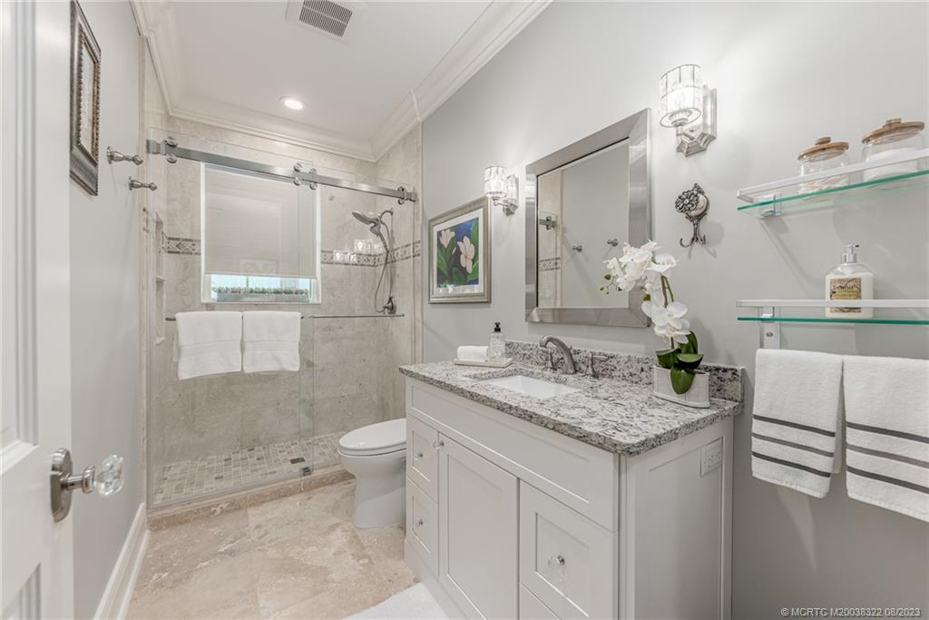 1455 Southeast Riverside Drive Stuart, FL 34996 - Photo 93 of 100 a bathroom with a granite countertop sink a toilet a mirror and shower