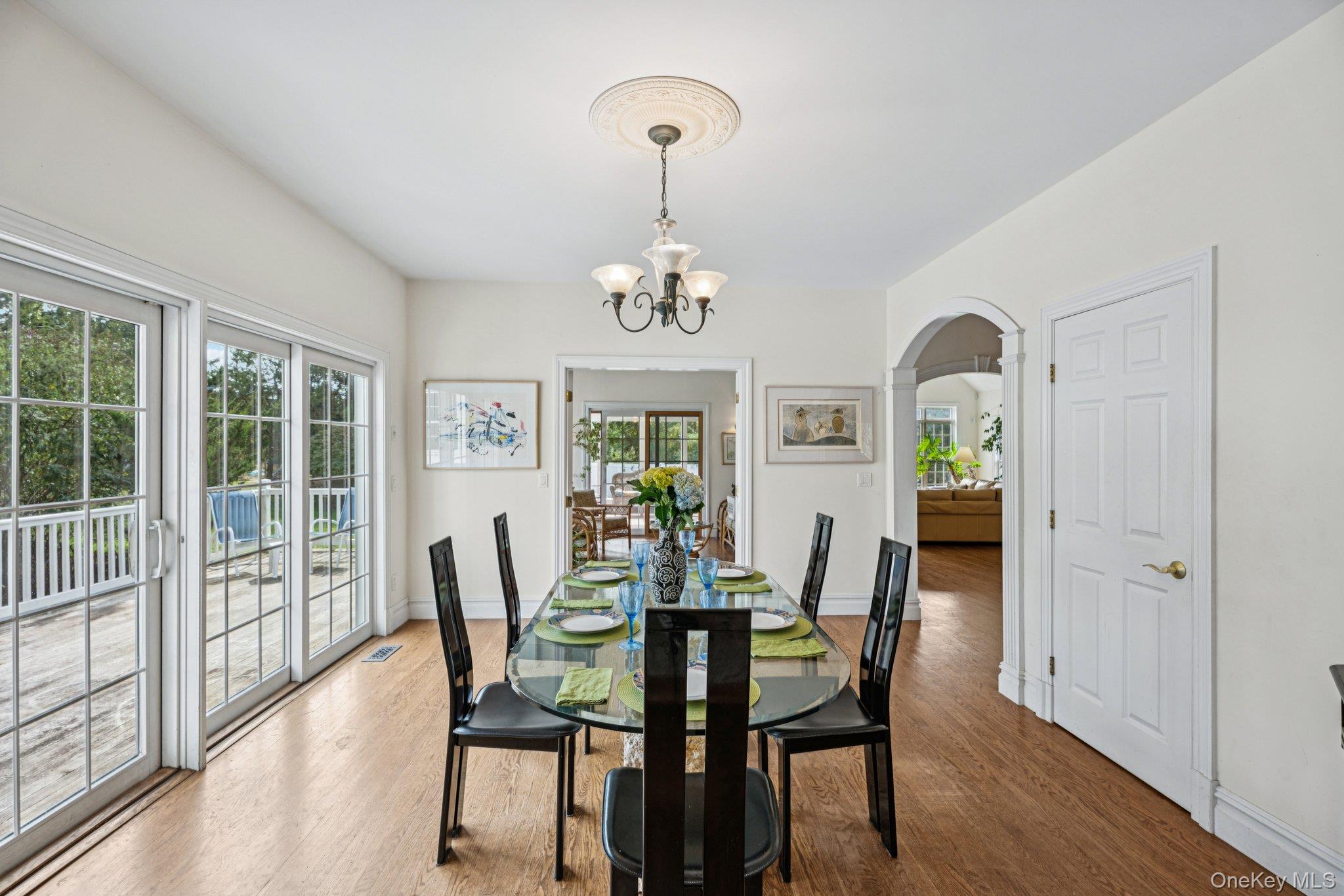 12 Laila Lane Remsenburg, NY 11960 - Photo 13 of 50 a view of a dining room with furniture wooden floor and chandelier