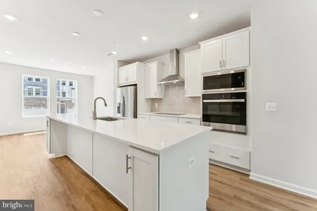 a kitchen with stainless steel appliances a sink stove and cabinets
