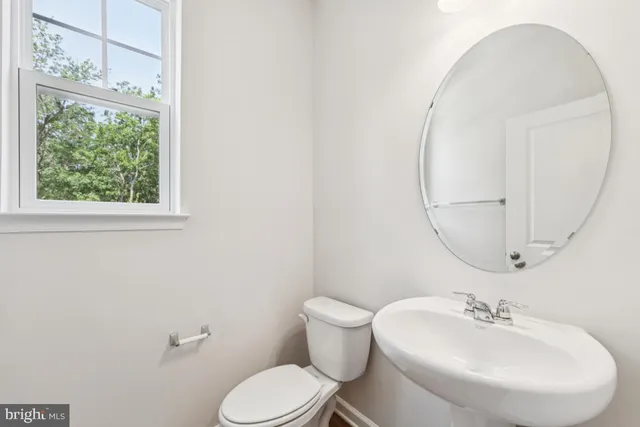 a bathroom with a sink mirror and toilet