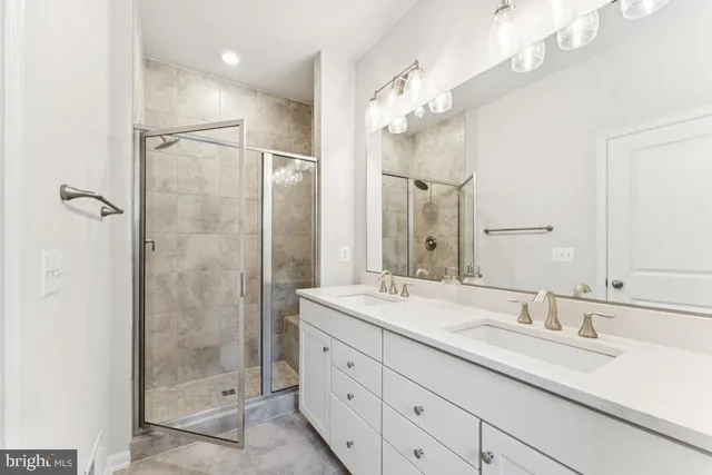 a bathroom with a granite countertop sink a mirror and a shower