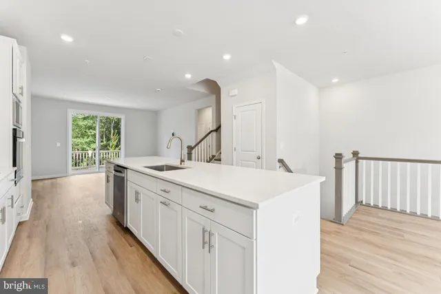 a kitchen with a sink and wooden floor