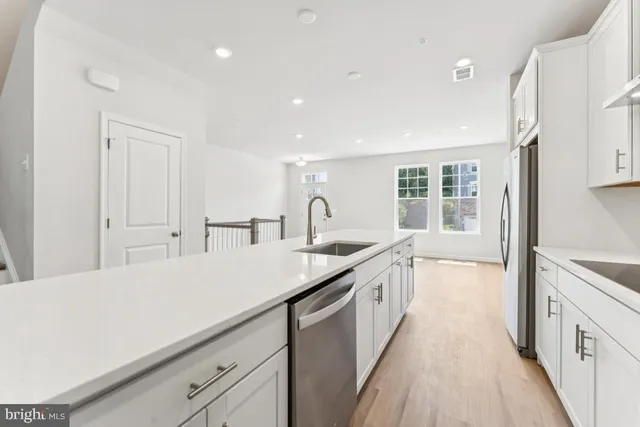 a large white kitchen with a sink and cabinets