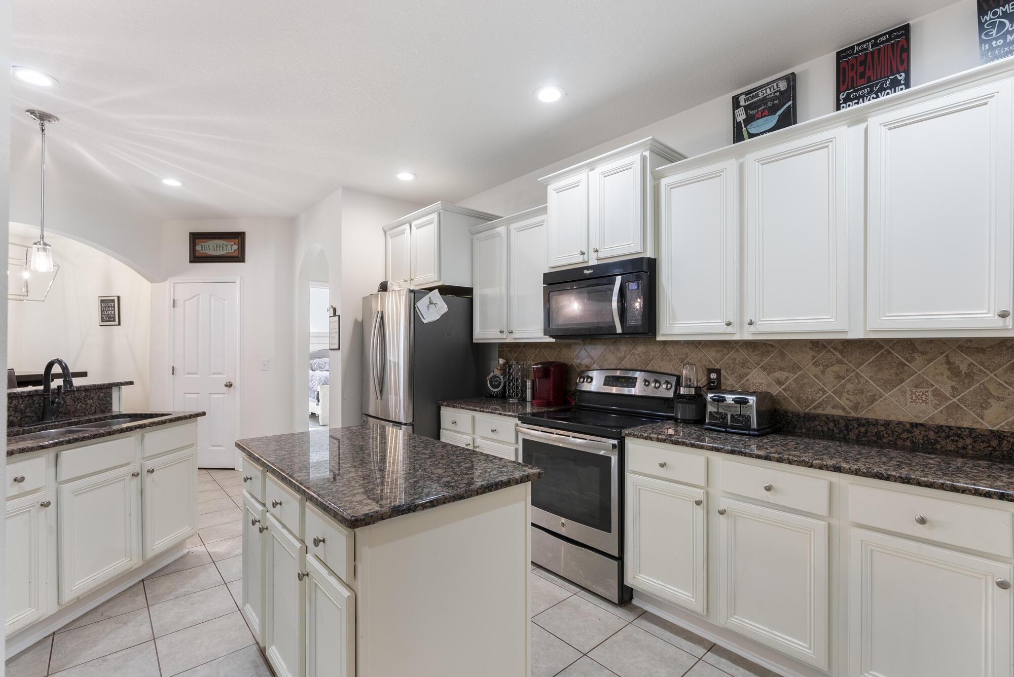 517 Pheasant Trail Crestview, FL 32536 - Photo 17 of 64 a kitchen with granite countertop white cabinets and stainless steel appliances