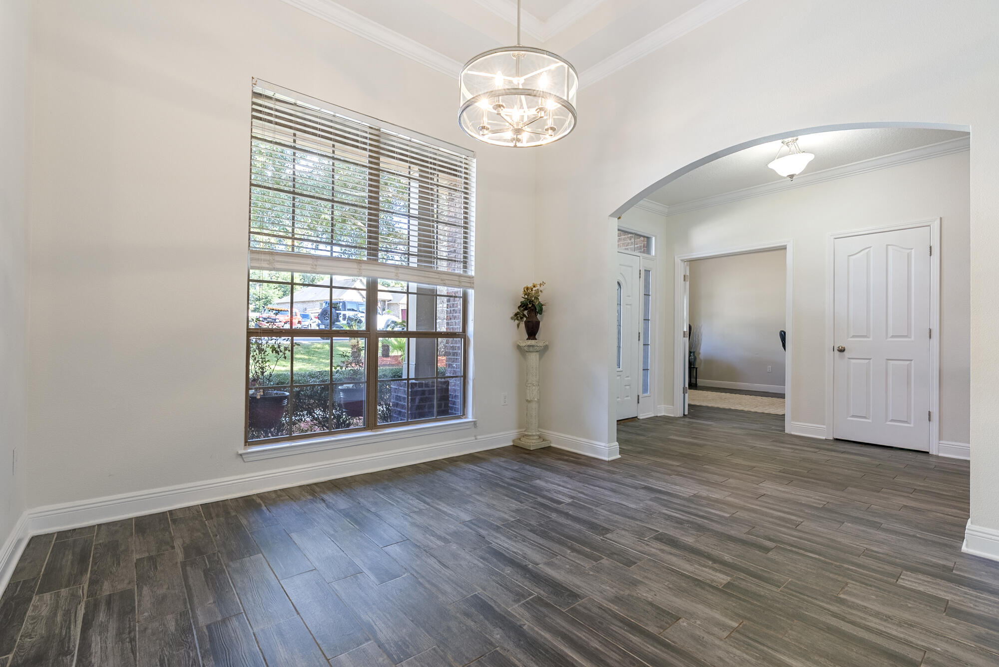 517 Pheasant Trail Crestview, FL 32536 - Photo 5 of 64 a view of an empty room with wooden floor and a window