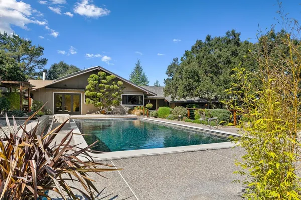 a view of a house with pool and sitting area