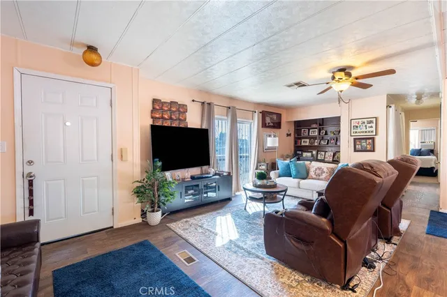 a living room with furniture wooden floor and a flat screen tv