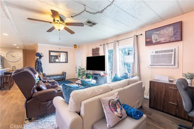 a living room with furniture kitchen view and a chandelier